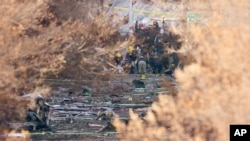 Investigators continue to look through the site of an explosion Monday, Dec. 28, 2020, in Nashville, Tenn. 