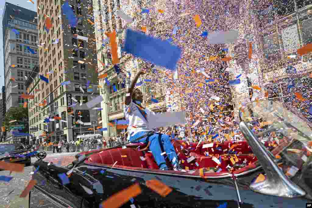 Grand marshal Sandra Lindsay, a health care worker who was the first person in the country to get a COVID-19 vaccine shot, waves to spectators as she leads marchers through the Financial District during a parade honoring essential workers for their efforts in getting New York City through the COVID-19 pandemic.