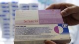 A clinic staff shows boxes of Infanrix and Pentaxim vaccines for infants at a children's clinic in Hong Kong, Tuesday, July 24, 2018, as they see a rise in the number of mainland parents bringing their children to Hong Kong for vaccinations following the 