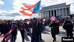 Ribuan demonstran membawa bendera nasional Puerto Rico dalam aksi demonstrasi di Washington DC hari Minggu (19/11). 