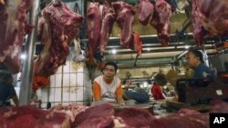 Para pedagang daging sedang menunggu pembeli di kios daging di sebuah pasar di Jakarta (Foto: dok). 