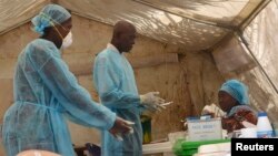 Health workers take blood samples for Ebola virus testing at a screening tent in the local government hospital in Kenema, Sierra Leone, June 30, 2014. 