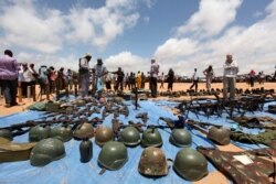FILE - Al-Shabab Islamist militants display weapons believed to be recovered peacekeepers suspected to have been killed during fighting in Somalia's capital Mogadishu, Oct. 21, 2011.