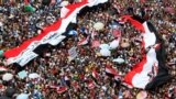 Supporters of the Muslim Brotherhood&#39;s presidential candidate Mohamed Morsi stand under giant Egyptian flags during a demonstration against the delay of the Egyptian presidential results at Tahrir Square in Cairo, June 22, 2012.