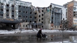 Seorang perempuan melewati gedung yang rusak akibat serangan militer Rusia di tengah serangan Rusia terhadap Ukraina di Kota Pokrovsk di wilayah Donetsk, Ukraina, Kamis, 12 Desember 2024. (Foto: Inna Varenytsia/Reuters)