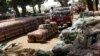 FIle - South Sudanese men inspect crates of soft drinks that were unloaded at the port in Juba, Southern Sudan.