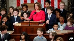 House Speaker Nancy Pelosi of California, surrounded by her grandchildren and other children, pounds the gavel at the Capitol in Washington, Thursday, Jan. 3, 2019. (AP Photo/Carolyn Kaster)
