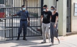 Two Chinese nationals wearing masks leave the infectious diseases hospital in Colombo, Sri Lanka, Jan. 28, 2020.