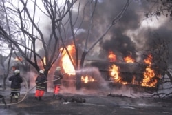 Fire fighters try to extinguish a Petrol Tanker blaze, Aug. 10 2019, in Morogoro, Tanzania.