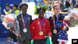 Mary Keitany, asal Kenya, tengah menjadi pelari pertama yang mencapai garis finish disusul oleh Sally Kipyego, asal Kenya, kiri, dan juara tiga Molly Huddle, asal AS, berpose di garis finish New York City Marathon 2016 (6/11). (foto: AP Photo/Seth Wenig)