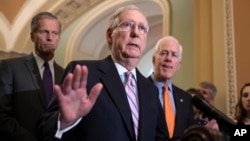 FILE - Senate Majority Leader Mitch McConnell, R-Kentucky, flanked by Sen. John Thune, R-South Dakota, left, and Majority Whip John Cornyn, R-Texas, speaks with reporters about Supreme Court nominee Brett Kavanaugh at the Capitol in Washington, Sept. 18, 2018.