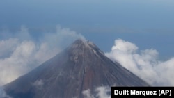 FILE - Smoke billows from the crater of Mayon volcano, one of the country's most active volcanoes, in Albay province about 550 kilometers southeast of Manila, Philippines, Feb. 26, 2014.