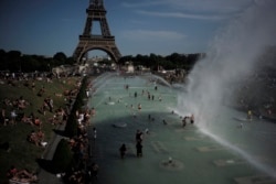 People cool off in the fountains of the Trocadero gardens, in front of the Eiffel Tower, in Paris, June 28, 2019.