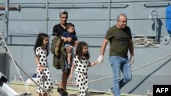 Des personnes d’un groupe de 58 migrants à la base maritime de Hay Wharf à Floriana, à Malte, le 30 septembre 2018.