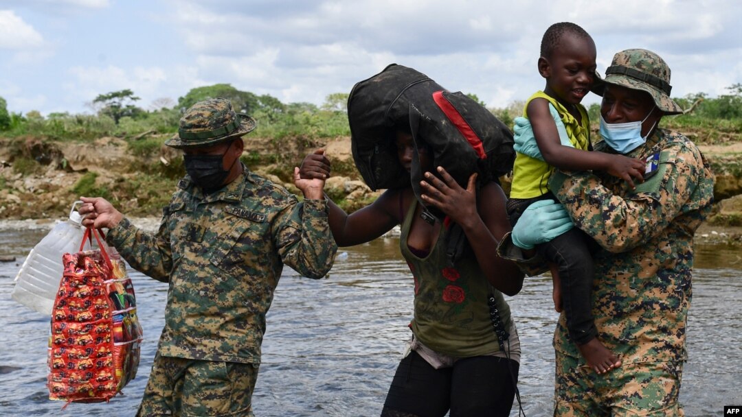 Miembros del Servicio Nacional de Fronteras de Panamá ayudan a los migrantes a cruzar el río Chucunaque después de que caminaron durante cinco días en el Darién Gap, en la aldea Bajo Chiquito, provincia de Darién, Panamá, el 10 de febrero de 2021.