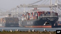 Cargo ships wait to be unloaded Tuesday, Jan. 5, 2010, at the Port of Oakland in Oakland, Calif.