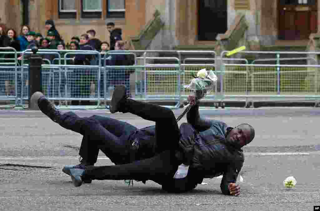Police officers apprehend a protester demonstrating against the government of Cameroon outside of the annual Commonwealth Day service at Westminster Abbey in London.