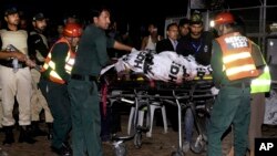 Pakistani rescue workers remove a dead body from the site of bomb explosion in a park in Lahore, March, 27, 2016. 