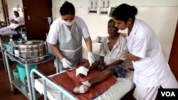 Nurses are dressing а wound on leprosy patient Gopal Bag, following amputation of his leg, at the Leprosy Mission Trust India hospital, Kolkata, Sept. 20 2016. (M. Hussain/VOA) 