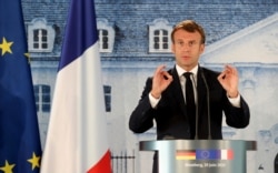 French President Emmanuel Macron gestures as he gives a press conference, at the German government's guest house Meseberg Castle in Gransee near Berlin, Germany, Monday, June 29 2020.