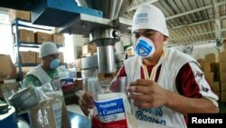 En la foto de archivo, un trabajador salvadoreño empaca productos en una empresa que exporta alimentos y bebidas locales a los salvadoreños que viven en los Estados Unidos. [Foto de archivo]
