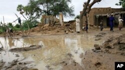 A picture released by Oxfam and taken on17 Aug 2010 shows people standing near homes destroyed by flooding near Zinder