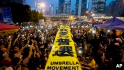 Manifestantes prodemocracia despliegan un letrero con la leyenda "Quiero un sufragio universal genuino" frente a las oficinas gubernamentales en Hong Kong.