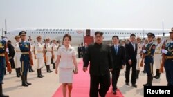 朝鲜领导人金正恩和夫人李雪主2018年6月19日抵达北京，中共中央政治局常委王沪宁迎接。