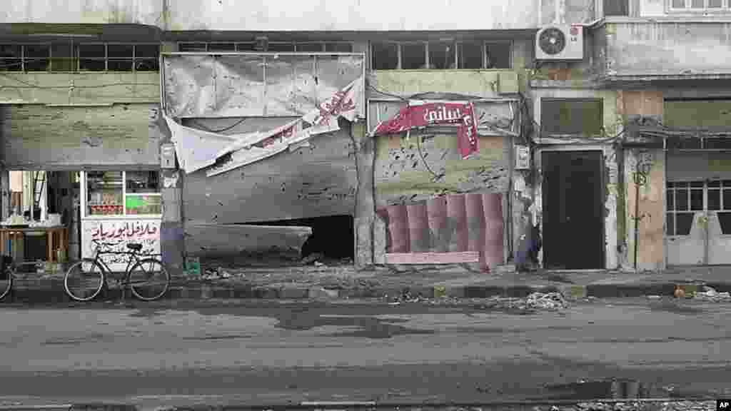 Damaged shops along an empty street in Homs, February 20, 2012. Syrian government forces unleashed a heavy artillery barrage on a rebel-held district of the city of Homs, activists said. (Reuters)