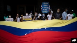 Los manifestantes ondean una bandera venezolana durante una manifestación de maestros, en Caracas, el 21 de octubre de 2020.