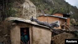 FILE - Uttara Saud, 14, sits inside a Chhaupadi shed in the hills of Legudsen village in Achham District in western Nepal, Feb. 16, 2014.