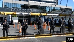 Riot police guard an entrance to the Legislative Assembly during a protest against the repeal of a law banning mining, in San Salvador, El Salvador, Dec. 23, 2024.