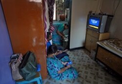 Family members stay indoors inside their single-room apartment at a Chawl, home to hundreds of families, during a 21-day nationwide lockdown to slow the spreading of coronavirus disease (COVID-19), in Mumbai, India, March 31, 2020.