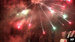 Anti-government protesters use fireworks against Lebanese riot police during a protest at a road leading to the parliament building in Beirut, Lebanon, Jan. 18, 2020. 