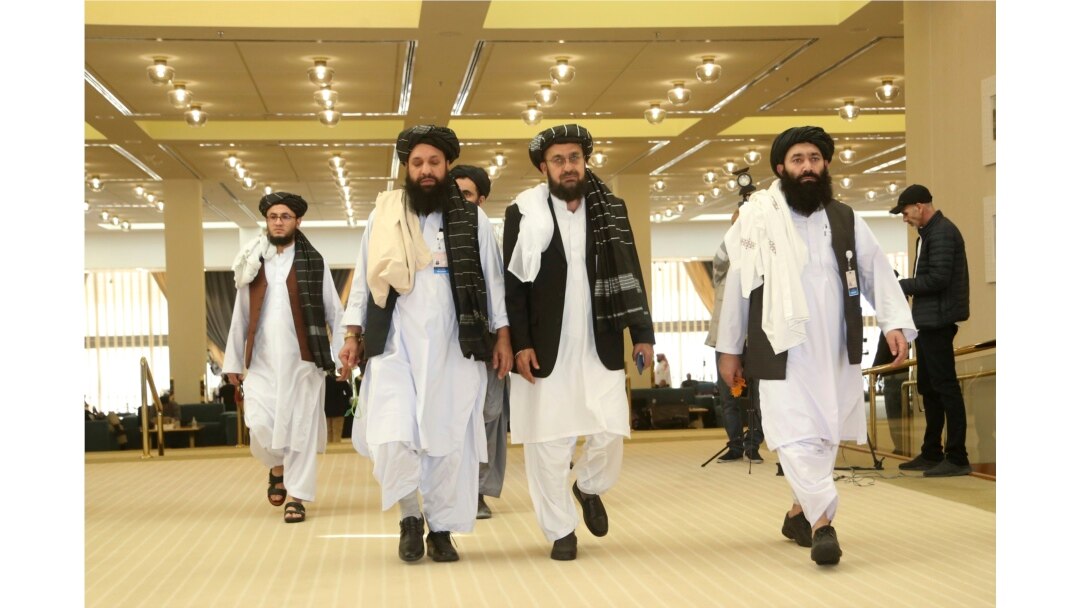 FILE - Members of Afghanistan's Taliban delegation arrive for the signing of an agreement between the Taliban and U.S. officials, in Doha, Qatar, Feb. 29, 2020.