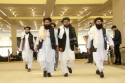 FILE - Members of Afghanistan's Taliban delegation arrive for the signing of an agreement between the Taliban and U.S. officials, in Doha, Qatar, Feb. 29, 2020.