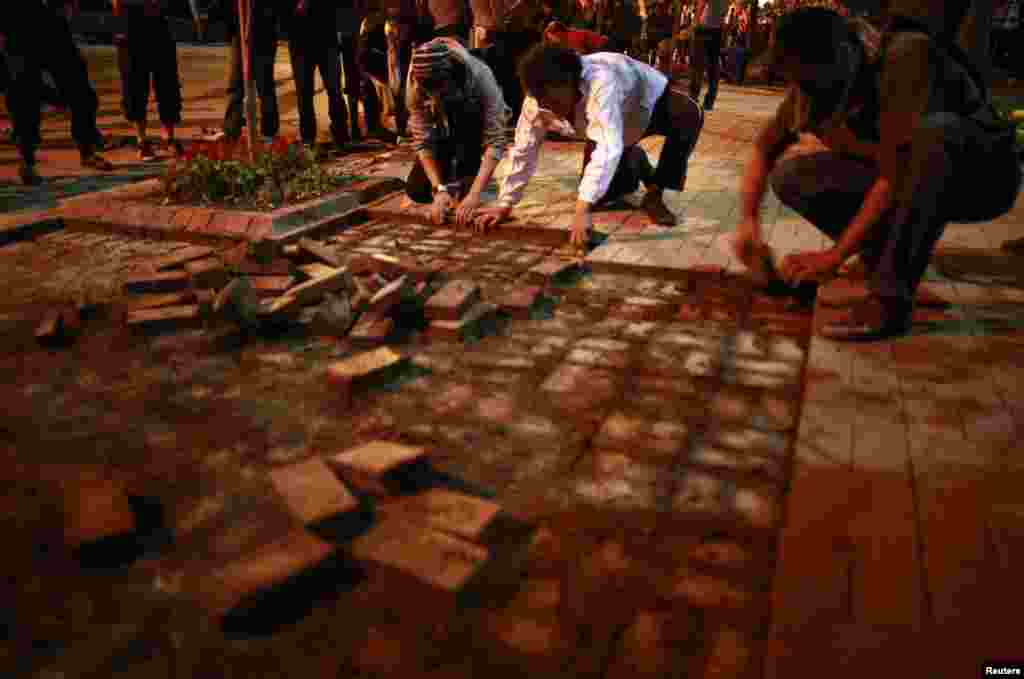 Anti-government protesters remove bricks from a sidewalk to build a barricade in central Ankara, June 9, 2013. 