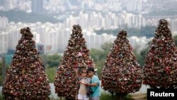 Sepasang kekasih mengambil swafoto atau selfie di atas bukit Namsan di pusat kota Seoul, Korea Selatan. (Reuters/Kim Hong-Ji)