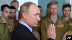 Russian President Vladimir Putin speaks to members of a student construction unit at the building site for a future secondary school in the village of Dubovoye, Belgorod Region, Russia, July 14, 2017.