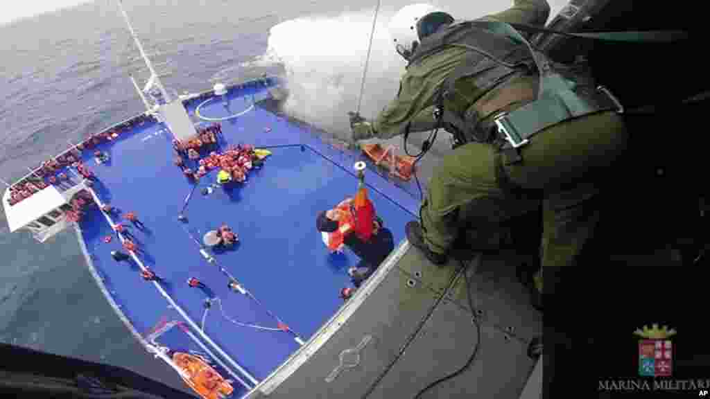 Dans cette image prise de la vidéo et publié par la marine italienne, une femme est soulevée depuis le pont du ferry battant pavillon italien Norman Atlantique par un hélicoptère de sauvetage après l&#39;incendie dans la mer Adriatique, le 28 décembre 2014.