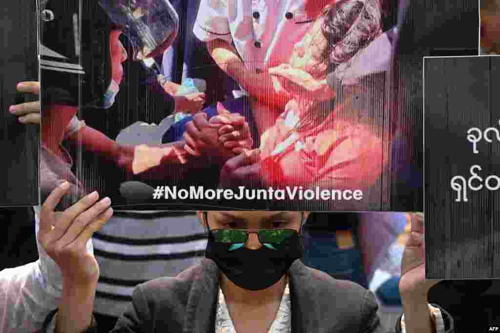 A protester holds up a poster with a portrait of Mya Thwate Thwate Khaing, who died from a gunshot wound after being shot in the head last week, during a demonstration against the military coup in Yangon.