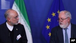 Iran's Vice President and Head of the Atomic Energy Organisation Ali Akbar Salehi, left, looks at European Union Climate Action and Energy Commissioner Miguel Arias Canete during a joint news conference in Brussels, Nov. 26, 2018. 