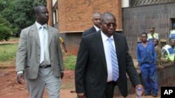 Elton Mangoma, centre, Zimbabwe's Minster of Energy and Power Development outside the magistrates courts, accompanied by two unidentified police detectives in Harare, March, 11, 2011