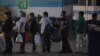 Guatemaltecos deportados desde Estados Unidos, que usan tapabocas como precaución contra el contagio del coronavirus, entran las instalaciones en las que guardarán cuarentena en la ciudad de Guatemala.