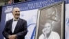 FILE - Dick Button smiles next to a painting of him as he's honored at the US Figure Skating Championships in San Jose, Calif., Jan. 4, 2018. 