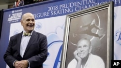 FILE - Dick Button smiles next to a painting of him as he's honored at the US Figure Skating Championships in San Jose, Calif., Jan. 4, 2018. 