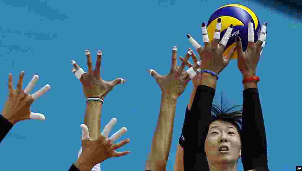 Yukiko Ebata of Japan spikes against Italy&#39;s blockers during the World Grand Prix Finals woman&#39;s volleyball match in Sapporo, northern Japan. Japan won 3-0.