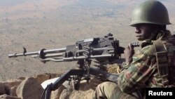 FILE - A Cameroonian soldier stands watch at an observation post in Mabass, northern Cameroon, where weeks earlier Boko Haram militants had kidnapped about 80 people, Feb. 16, 2015. 