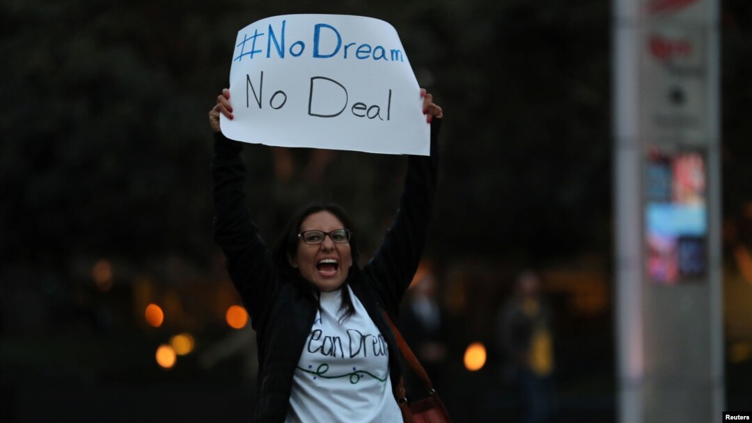 FILE - A demonstrator, part of a group blocking traffic, demands action by the federal government on the Deferred Action for Childhood Arrivals program in San Diego, Calif., Dec. 4, 2017. 