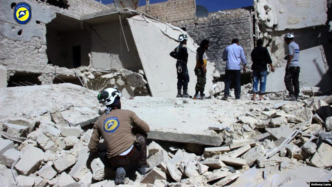Anggota kelompok Pertahanan Sipil Suriah, White Helmets, memerika kerusakan bangunan akibat serangan udara di daerah Bustan al-Qasr di Aleppo, Suriah (25/9). 